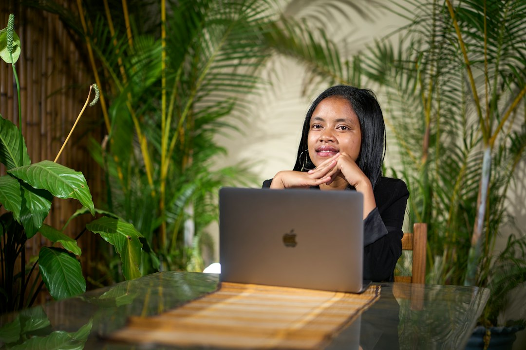 Young woman working on a laptop surrounded by plants