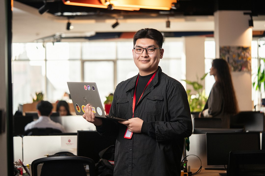 Man holding a laptop in a modern office setting